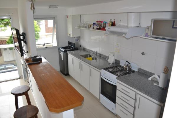 cocina con electrodomésticos blancos y encimera de madera en Departamento Premium 2 ambientes a 600 metros de la playa Totalmente equipado en Mar del Plata