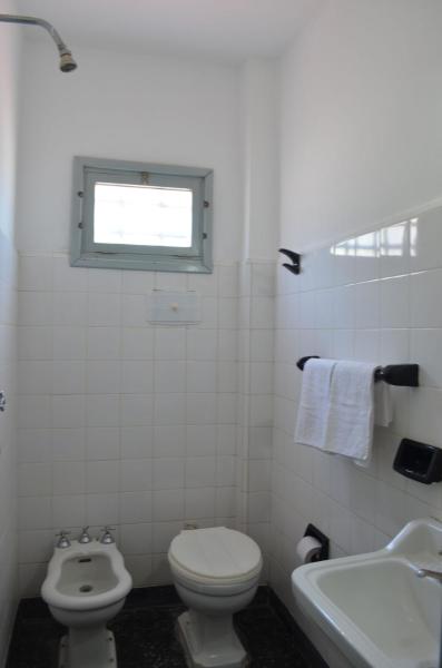 un baño con aseo y aseo y una ventana en el Hotel Marino de Villa Gesell