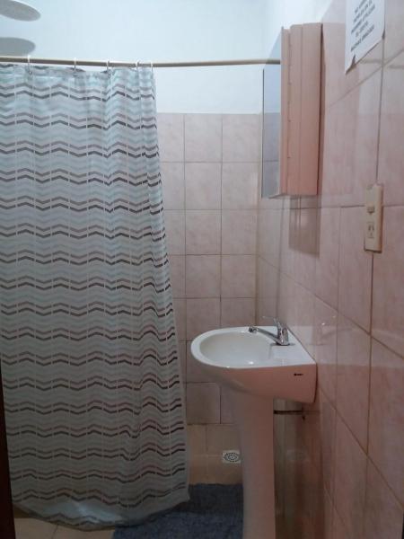 baño con lavabo y cortina de ducha en Casa vacacional en Puerto Iguazú