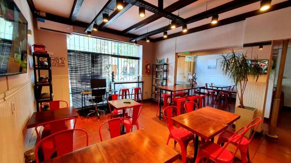 un restaurante con mesas de madera y sillas rojas en Hotel Positano en Mar del Plata