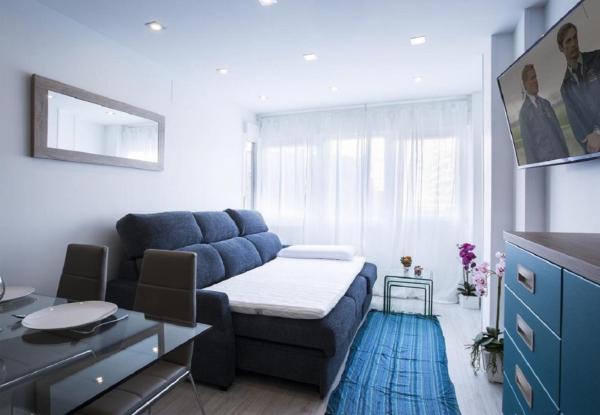 sala de estar con sofá azul y alfombra azul en MIT House Avenida America Confort XIII en Madrid, en Madrid