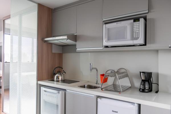 a kitchen with a microwave and a sink at Studio Premium Batel Twin - HSB001 in Curitiba