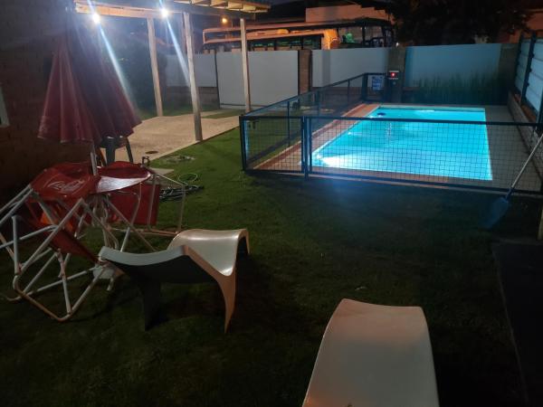 una piscina por la noche con mesa y sillas en Comoda casa en el centro de Villa Carlos Paz, pileta privada, cinco minutos a pie de la peatonal, aire, porton electrico, en Villa Carlos Paz