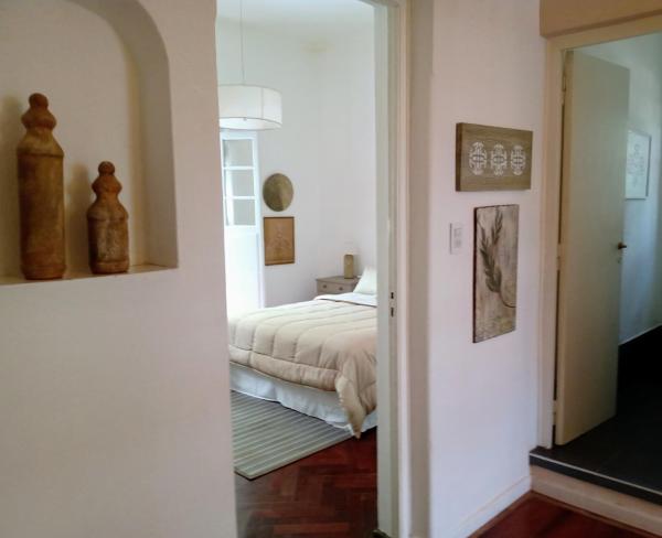 1 dormitorio con cama y espejo en CASA ARISTIDES en Mendoza