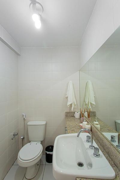 Baño blanco con aseo y lavamanos en Aconchegante Duplex no Brooklin III, en São Paulo