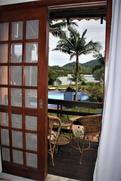 a door leading to a patio with a table and chairs at Saint Germain - Lagoa da Conceição in Florianópolis
