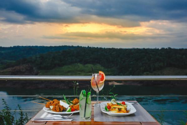 una mesa con 2 platos de comida en el balcón en Hotel Guaminí Misión en Puerto Iguazú