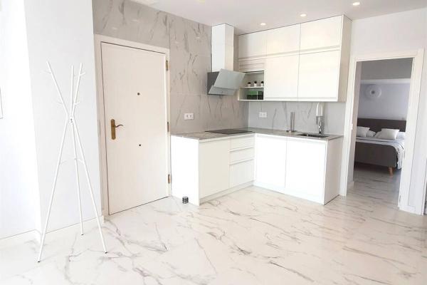 una cocina blanca con armarios blancos y una puerta en SKOL 645. Exclusive Three Bedrooms Apartment with Sea Views, en Marbella