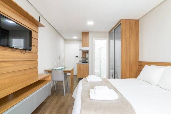 1 dormitorio con 1 cama, escritorio y TV en BHomy Bela Vista Moderno com varanda BS37, en São Paulo