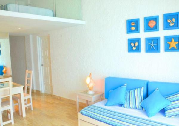 sala de estar con sofá azul y mesa en Apartamento Front en la Playa Cancun Mexico, en Cancún