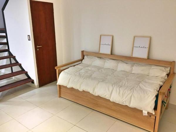 una cama en una habitación con suelo de madera en Departamento en Ushuaia 2 con.  amplio en Ushuaia