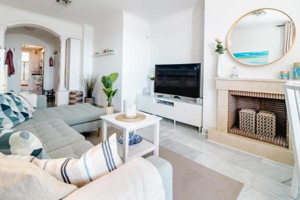 sala de estar con chimenea y TV en 2-Bedroom Retreat with Stunning Views in Aldea Blanca with Private Paddle Court, en Marbella