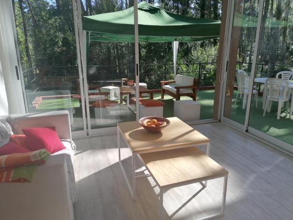 un porche cubierto con una mesa y una sombrilla verde en Casa Villa Celeste en Balneario Mar Azul