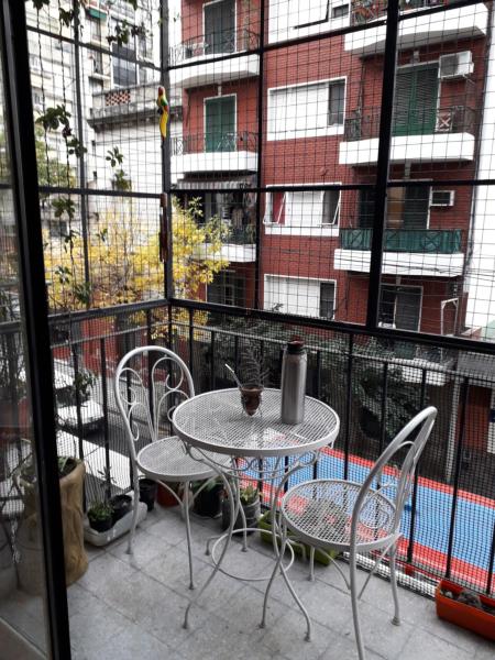 una mesa y sillas en un balcón con un edificio en Departamento zona congreso con balcón a la calle en Buenos Aires