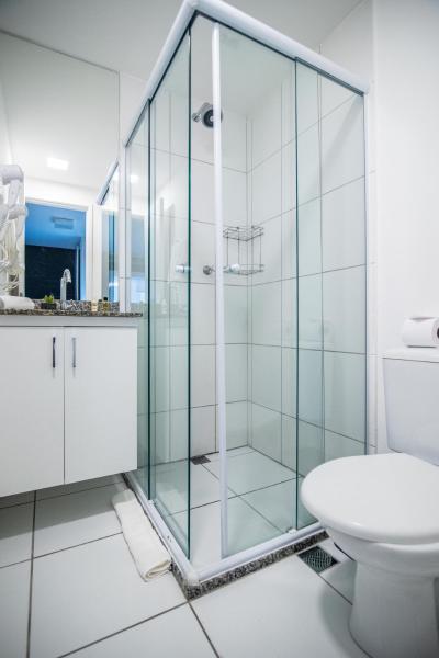 y baño con ducha de cristal y aseo. en 360 Suítes Vibe República - Apartamentos mobiliados, en São Paulo