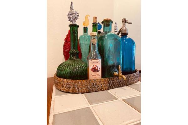 un grupo de botellas sentadas en la parte superior de un mostrador en MRG - Casa Italiana 3D - 550 metros da Rua Coberta, en Gramado
