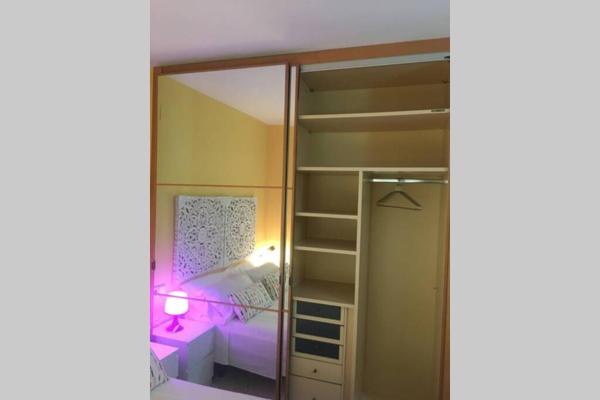 1 dormitorio con armario y espejo en Confortable-tranquilo apartamento junto al centro, en Málaga