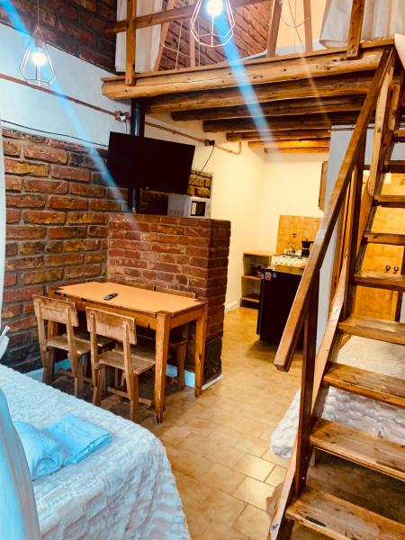 un comedor con una mesa de madera y escaleras en Bungalows Luz del sur en San Carlos de Bariloche