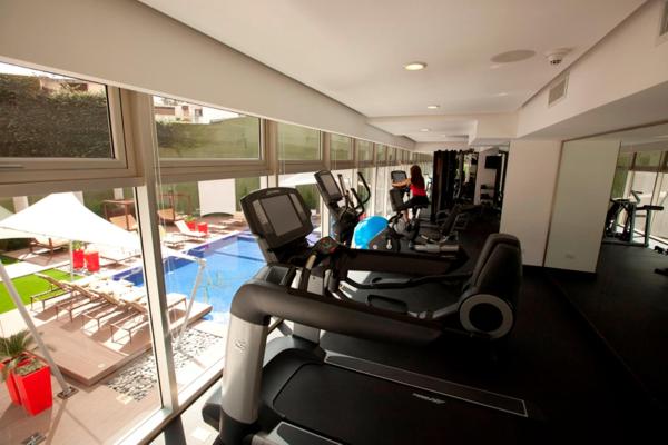 un gimnasio con equipo cardiovascular y una piscina en Adriatika Hotel & Residence, en Guatemala