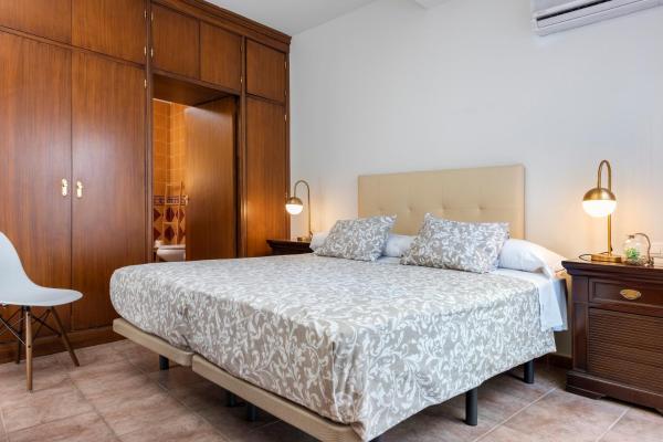 1 dormitorio con 1 cama y armario de madera en HSH Suites Triana, en Sevilla