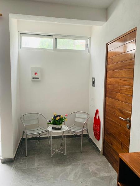 una mesa con dos sillas y un jarrón de flores.  en Centrico Departamento 201, en Cancún