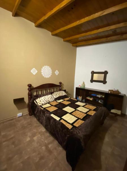 1 dormitorio con 1 cama a cuadros en una habitación en Casa de Fin de semana en Iguazú en Puerto Iguazú