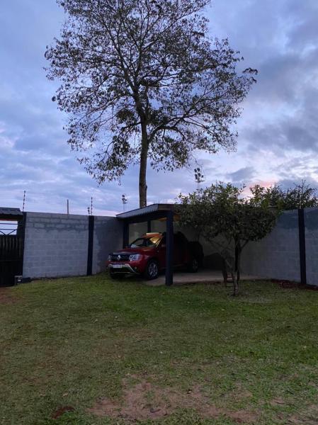 un coche aparcado bajo un cobertizo junto a un árbol en Casa de Fin de semana en Iguazú en Puerto Iguazú