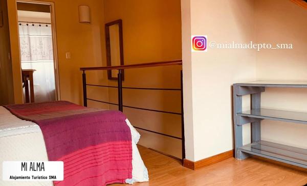 Habitación con cama y escalera en M I A L M A Departamento Turistico en San Martín de los Andes