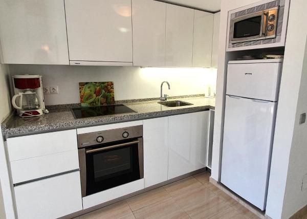 cocina con armarios blancos, fregadero y fogones en Skol 216 1Bedroom Duplex First Line Beach, en Marbella