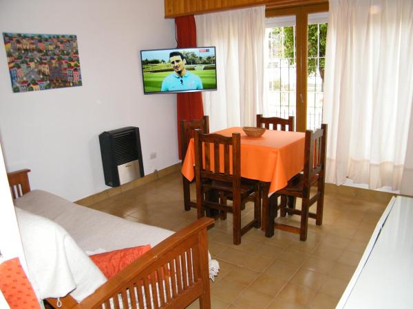 un comedor con mesa y tv en la pared en el pucará de Villa Gesell
