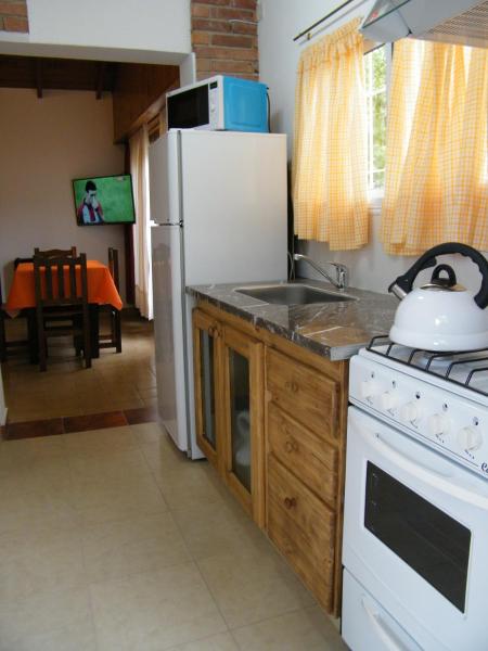 una cocina con nevera blanca y fregadero en pucará en Villa Gesell