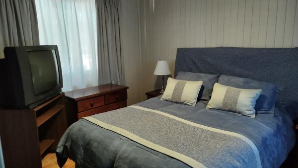 1 dormitorio con 1 cama y Tv LED en Casa CAVOK en San Carlos de Bariloche