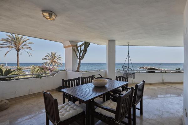 un comedor con mesa y sillas y el océano en Seafront Apartment with 2 bedrooms in Puerto Banús, en Marbella