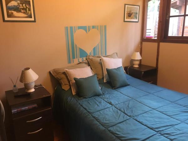 Un dormitorio con una cama azul con un corazón.  en Cabañas Entre Pinos en Villa Gesell