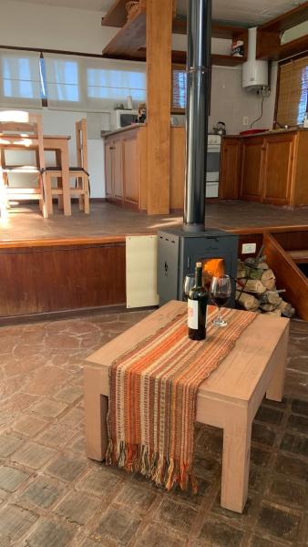 una mesa con una botella de vino y una copa en Alma Surena en Balneario Mar Azul