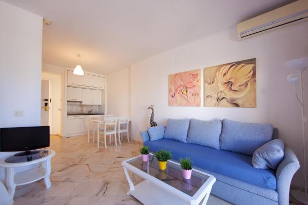 sala de estar con sofá azul y mesa en Romana Playa studio Elviria, en Marbella