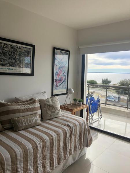 1 dormitorio con cama y vistas al océano en Edificio Soles en Puerto Madryn