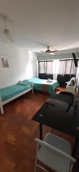 Habitación con 2 camas y mesa. en Greta Apartment II en Mendoza