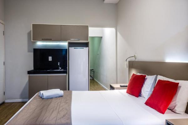 1 dormitorio con 1 cama blanca grande con almohadas rojas en Injoy Lofts Ipanema, en Río de Janeiro