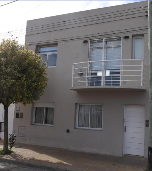 una casa gris con una puerta y ventanas blancas en Vista Parque Independencia. en Tandil