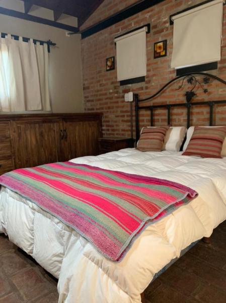 Un dormitorio con una cama con una manta a rayas. en Monte Barranco, en Villa Yacanto