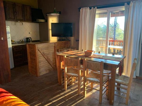 cocina con mesa de madera y sillas y cocina con ventana en Monte Barranco, en Villa Yacanto