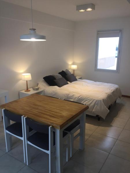 1 dormitorio con cama y mesa de madera en Monoambiente Céntrico único en Puerto Madryn