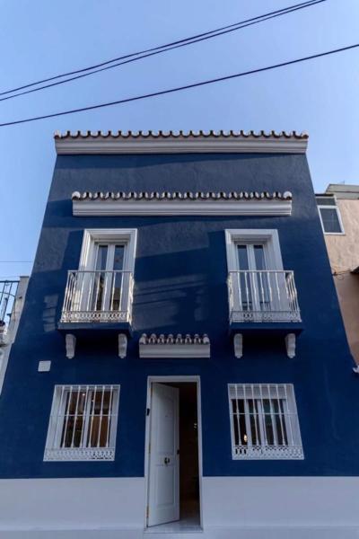 una casa azul con dos ventanas y una puerta a Casa Mariel, en Málaga