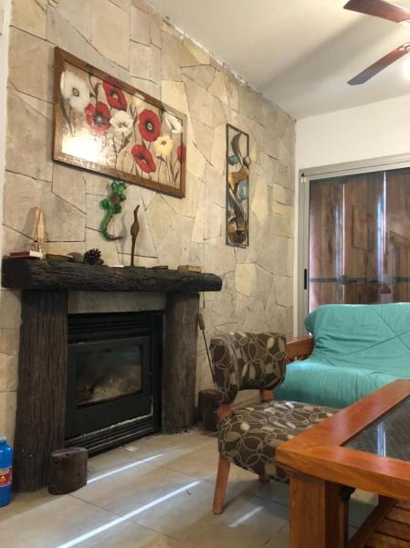sala de estar con chimenea y sofá en casa alto en Balneario Mar Azul