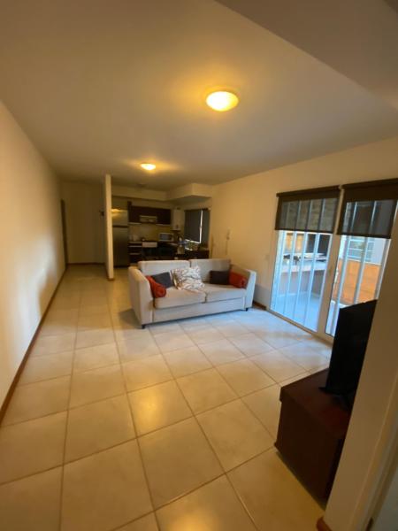 una sala de estar con un sofá blanco en una habitación en EDIFICIO CORAL 2 Dormitorio Y EDIFICIO ARENAS 1 Dormitorio en Puerto Madryn