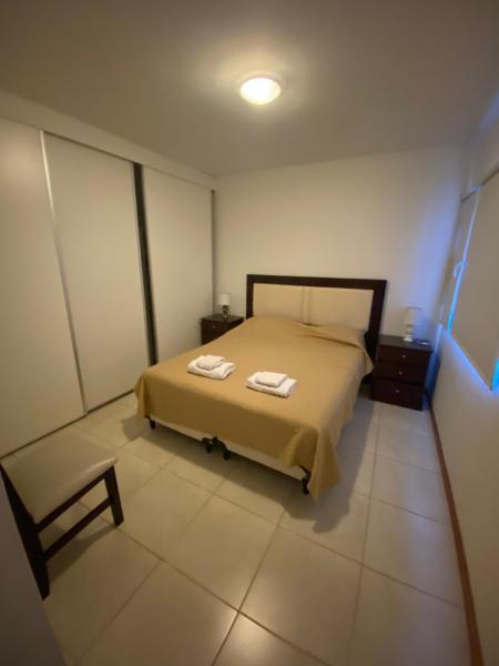 1 dormitorio con 1 cama con 2 toallas en EDIFICIO CORAL 2 Dormitorio Y EDIFICIO ARENAS 1 Dormitorio en Puerto Madryn