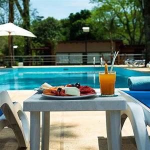 una bandeja de comida y una bebida en una mesa cerca de una piscina en Gran Hotel Tourbillon & Lodge en Puerto Iguazú