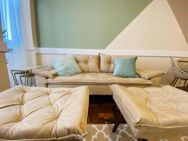sala de estar con sofá y taburete en MRG - Charmoso 2D na Rua Coberta, en Gramado