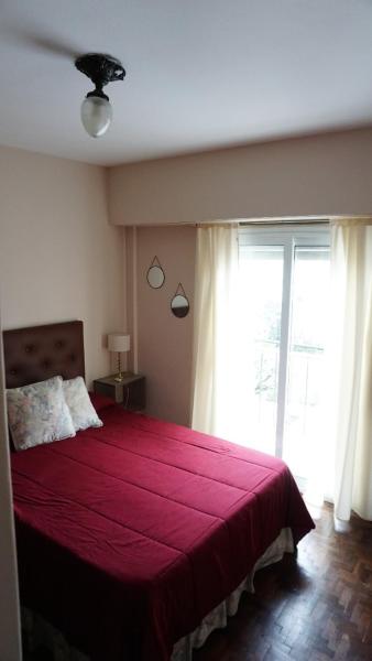 1 dormitorio con cama roja y ventana grande en vista hermosa en Tandil